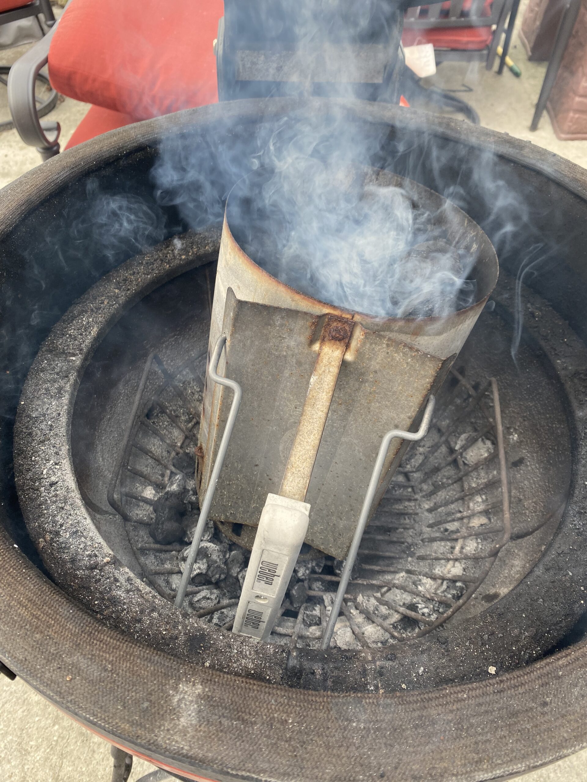 charcoal chimney with lit charcoal inside kamado