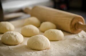 dough balls and rolling pin on floured surface